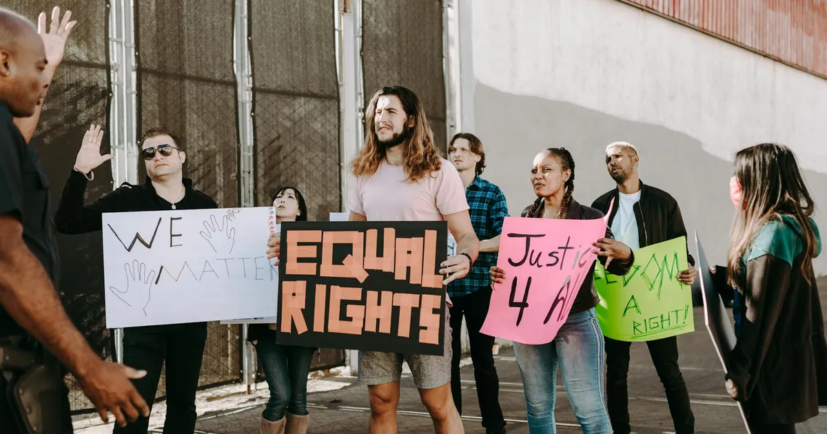 A group of diverse protesters holding signs advocating for equal rights during a peaceful street demonstration.