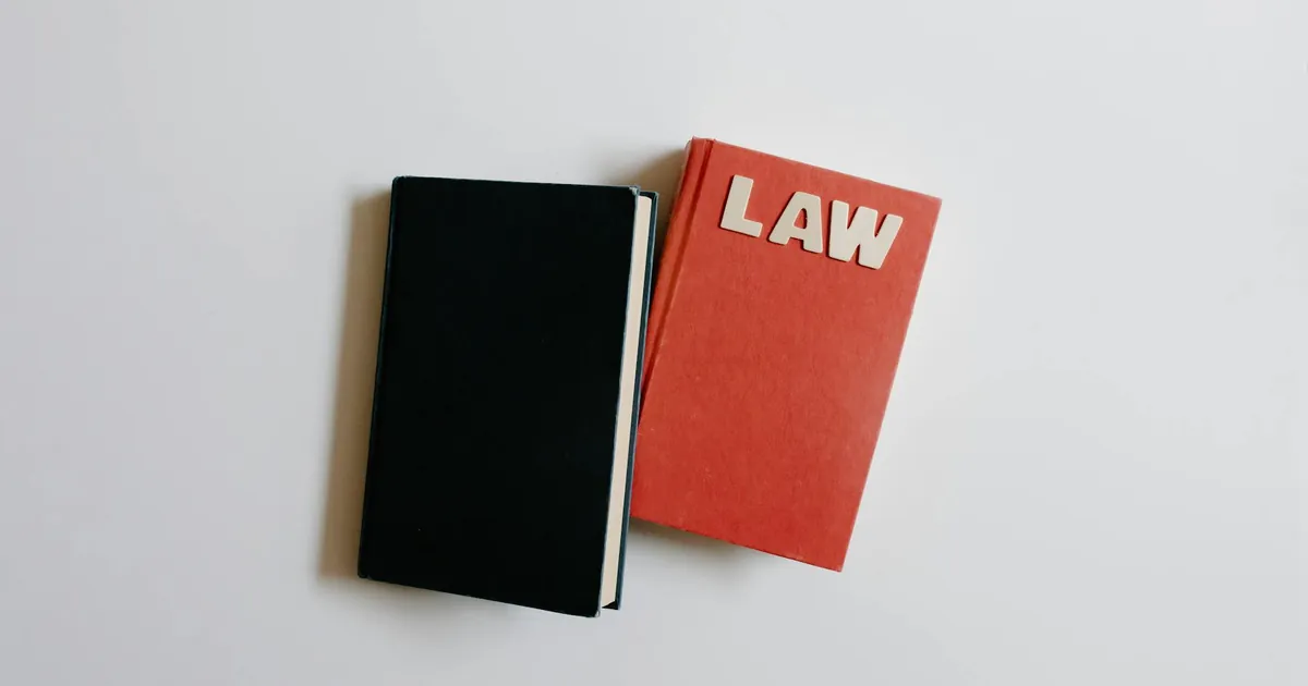 Top view of a law book and black notebook on a white surface, perfect for educational themes.