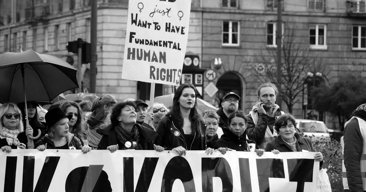 A powerful black and white image of women protesting for fundamental human rights in a city setting.
